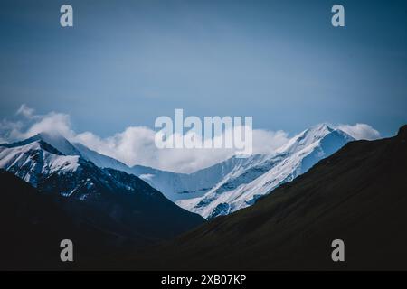 Fangen Sie die atemberaubende Schönheit der schneebedeckten Berge Alaskas ein. Diese atemberaubende Landschaft zeigt die unberührten Gipfel vor einem klaren Himmel, ideal für Stockfoto