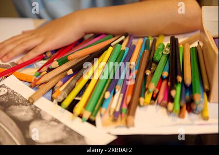 Nahaufnahme von Kinderhänden mit Buntstiften in einer Kunstklassenwerkstatt Stockfoto