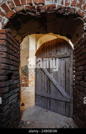 Alte geöffnete Holztür in einem alten roten Backsteingebäude. Stockfoto