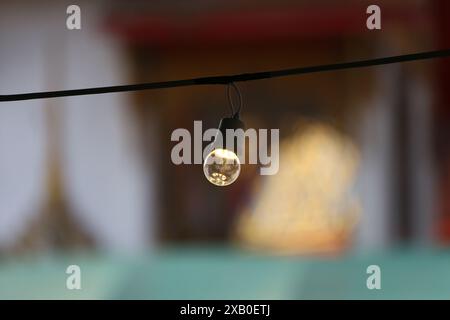 Eine Glühlampe, die am Geländer hängt, ein Lampensatz zum Aufhängen mit mehreren Lichtern. Stockfoto