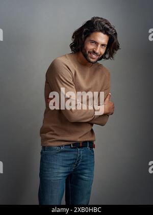 Mode, Lächeln und Porträt eines Mannes im Studio mit überkreuzten Armen für stilvolles, elegantes und winterliches Outfit. Glücklich, Selbstvertrauen und Model aus Australien mit Stockfoto