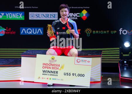 Jakarta, Indonesien. Juni 2024. SHI Yu Qi aus China posiert für Fotos mit der Trophäe auf dem Podium, nachdem er am 6. Tag der Kapal API Indonesia Open im Istora Gelora Bung Karno am 9. Juni 2024 in Jakarta, Indonesien das Finale der Einzelspiele gewonnen hat Stockfoto