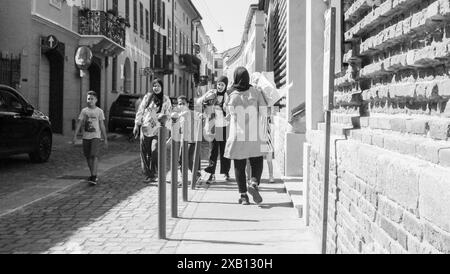 Cremona, Italien - 16. Mai 2024 Schwarzweiß-Foto einer muslimischen Familie, die in einer Stadt in europa einen Bürgersteig entlang geht Stockfoto