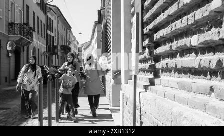 Cremona, Italien - 16. Mai 2024 eine fröhliche muslimische Familie, die die Straßen italiens erkundet, in traditioneller Kleidung gekleidet und die Sehenswürdigkeiten des C Stockfoto