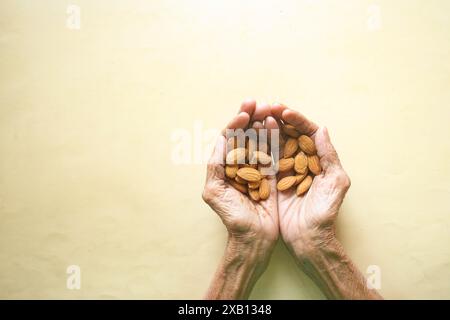Mandelnüsse auf einer älteren Frauenhand Stockfoto