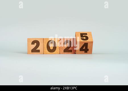 Drehen Sie die Holzwürfel 2024 in Richtung 2025 auf grauem Hintergrund Stockfoto