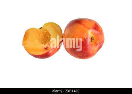 Zwei Nektarinenfrüchte, eine ganze und die Hälfte der anderen. Süßes, saftiges Dessert zum Frühstück. Stockfoto