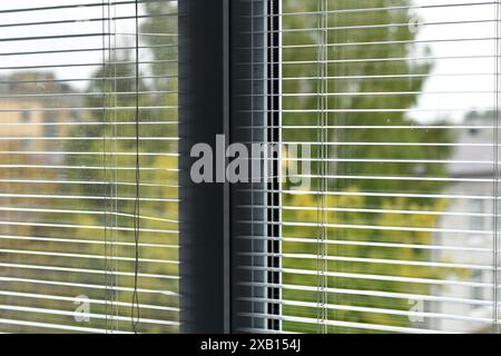 Innenansicht des verstellbaren Fenstervorhangs mit Sonnenschein von außen, venezianische Jalousien, Sonnenschirme, Fensterläden, Fensterjalousien und Sonnenschirme. Stockfoto