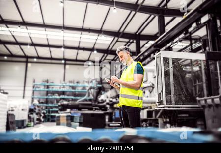 Lagerarbeiter liest Produktauftrag, Kommissionierung. Lagerleiter überprüft Lieferung, Lagerbestand, prüft Produkte für die Lieferung. Stockfoto