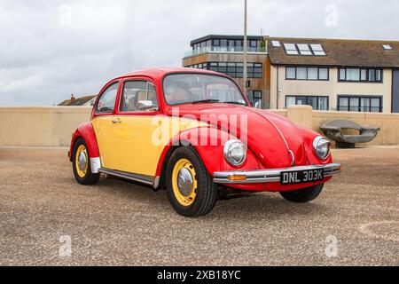 1972 70er Jahre Roter gelber VW Volkswagen 1300 Käfer; parkt an der Strandpromenade von Urugueys, Großbritannien Stockfoto