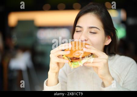 Glückliche Frau isst Einbrecher in einem Restaurant Stockfoto