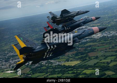 Ein F-15C Eagle und ein Paar von aufgedruckten F-15E Strike Eagles, die dem 48th Fighter Wing zugeordnet sind, führen zur Unterstützung eine Fliege über der Normandie, Frankreich, durch Stockfoto