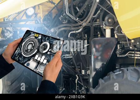 Servicemitarbeiter mit digitalem Tablet neben Mähdrescher mit offener Motorhaube Stockfoto