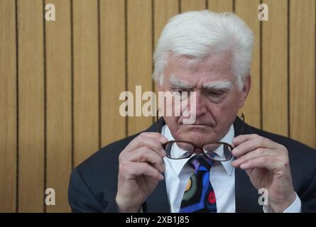 10. Juni 2024, Schleswig-Holstein, Lübeck: Der „Euroimmun“-Gründer Winfried der „Euroimmun“-Gründer Winfried Stöcker sitzt vor dem Gerichtssaal vor dem Amtsgericht vor dem Beginn seines Strafverfahrens für eine Impfkampagne mit seinem eigenen Corona-Impfstoff im November 2021. Stöcker hatte im November 2021 auf seinem Flughafen in Blankensee 50 Freiwillige mit seinem inoffiziell zugelassenen Impfstoff „Lubeca Vax“ geimpft. Im März 2023 erließ das Amtsgericht Lübeck eine Strafverfügung und Geldbuße gegen den damals 76-Jährigen. Foto: Marcus Brandt/dpa Stockfoto