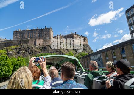 Gruppe von Touristen, die eine Tour im offenen Bus durch Edinburgh genießen, vorbei an Edinburgh Castle Stockfoto