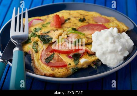 Pilz- und Tomatenomelette mit einer Portion Hüttenkäse. Stockfoto