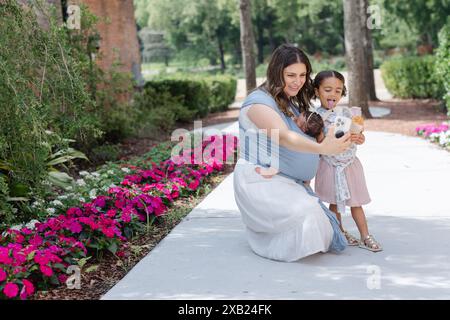 Mom und Tochter machen draußen dumme Gesichter, während sie Selfie machen Stockfoto