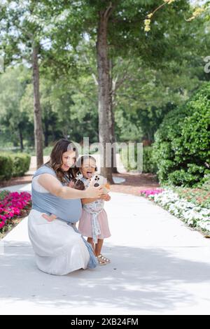 Mom und Tochter machen draußen dumme Gesichter, während sie Selfie machen Stockfoto