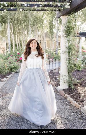 Glückliche Frauen, die mit langem Kleid im Garten laufen Stockfoto