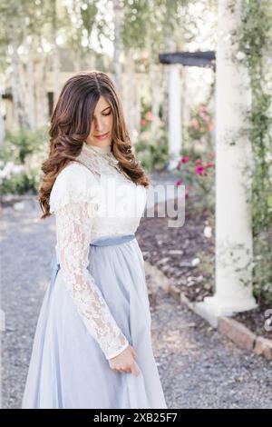 Frauen im Garten, die auf ein schieferblaues Kleid herabschauen Stockfoto