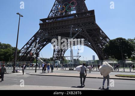 pic zeigt: Straßenhändler vor dem Eiffelturm, während sich die Stadt auf die Olympiade vorbereitet, mit Straßensperrungen und Aufräumarbeiten, die das tägliche Leben von Par stören Stockfoto