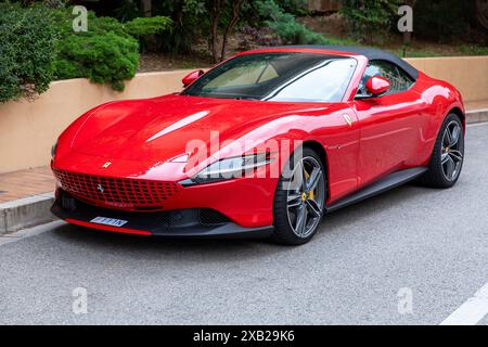 Monte-Carlo, Monaco - 9. Juni 2024: Ein eleganter roter Ferrari Roma Sportwagen parkt auf einer Straße. Das luxuriöse Fahrzeug besticht durch seine leuchtenden Farben und Stockfoto