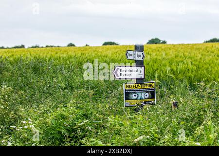 Wegweiser mit dem Richtungsweg, dem Restricted Byway und dem No Fly Tipping an einem Posten in der Landschaft von Wiltshire Stockfoto