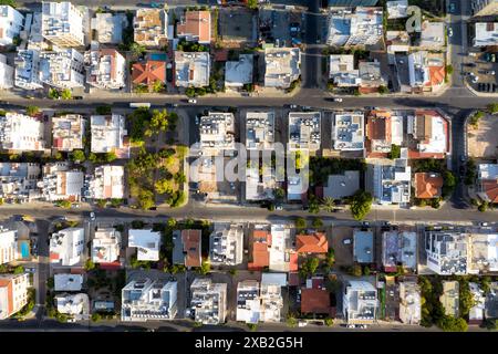 Top-Down-Drohnenaufnahme, die das urbane Muster der Straßen und Gebäude in der Abenddämmerung erfasst. Limassol, Zypern Stockfoto