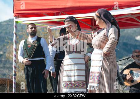 Limnatis, Zypern - 24. Dezember 2022: Frauen in traditionellen zyprischen Kostümen spielen einen lebhaften Volkstanz beim Mandelbaumblüten-Festival Stockfoto