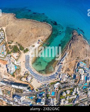 Blick aus der Vogelperspektive auf ein atemberaubendes Sandy Bay Beach (Vathia Gonia) Resort mit türkisfarbenem Wasser und umliegender Stadtlandschaft. Ayia Napa, Zypern Stockfoto