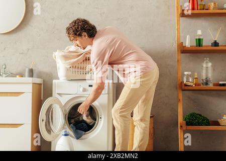 Ein Mann in kuscheliger Hauswäsche, der etwas in einer Waschmaschine macht. Stockfoto