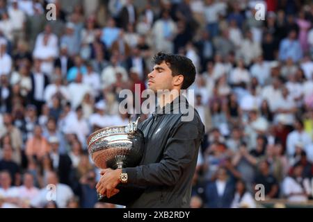 Paris, Frankreich. Juni 2024. Carlos Alcaraz aus Spanien hält seine Trophäe, als die Nationalhymne am Ende seines letzten Spiels gegen Alexander Zverev aus Deutschland bei den French Tennis Open in Roland Garros in Paris am Sonntag, den 9. Juni 2024, ausgestrahlt wird. Alcaraz gewann die French Open-Titel mit 3:6, 6:2, 7:5, 1:6, 2:6. Foto: Maya Vidon-White/UPI Credit: UPI/Alamy Live News Stockfoto