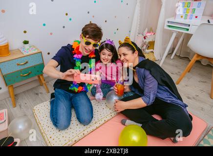 Familie, die einen spielerischen Moment im Kinderzimmer hat, während sie ein Selfie macht Stockfoto
