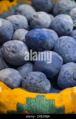 Nahaufnahme von saftigen Heidelbeeren, die während einer Oman-Reise ausgestellt werden, mit einer lebhaften Marktstruktur im Hintergrund Stockfoto