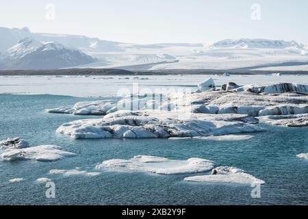 Faszinierender Blick auf Eisberge, die sich in der ruhigen Lagune des Gletschers Jokulsarlon auf Islands dramatische schneebedeckte Landschaften und den klaren blauen Himmel, die Darstellungen darstellen Stockfoto