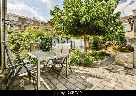 Ein ruhiger Essbereich im Freien in der Roggebotstraat, Amsterdam, mit einer Terrasse, umgeben von üppigem Grün und Wohnhäusern Stockfoto