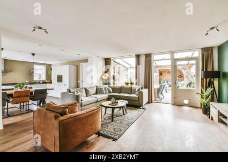 Elegantes Wohnzimmer mit offenem Raum verbindet modernen Stil mit Komfort in Sikkelstede. Dieser einladende Bereich verfügt über trendige Möbel, große Fenster, Stockfoto