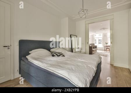 Ein stilvolles Schlafzimmer mit einem Plüschbett und offenem Eingang in der Blassiusstraat 5-1, das einen Blick auf das angrenzende Zimmer bietet Stockfoto