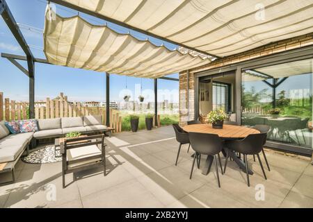 Dieses Bild zeigt eine moderne Terrasse in der Duintopstraat, mit stilvollen Gartenmöbeln, einem schützenden Sonnenschirm und Blick auf eine urbane La Stockfoto