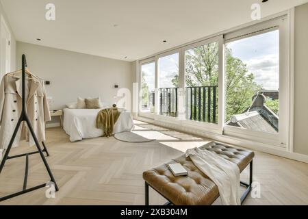 Moderne Einrichtung mit Tageslicht und minimalistischer Einrichtung, Balkon mit Blick auf Fischgrätenboden und eleganten Möbeln. Stockfoto