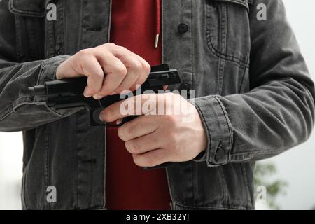 Gefährlicher Krimineller mit Waffe im fremden Haus, Nahaufnahme. Bewaffneter Raub Stockfoto