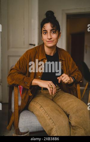 Porträt einer jungen Frau, die zu Hause auf einem Stuhl sitzt Stockfoto