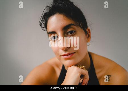 Nahporträt der jungen Frau vor weißer Wand Stockfoto