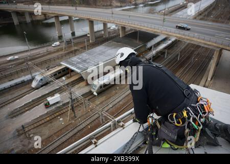 Hochwinkelansicht eines männlichen Seilarbeiters, der auf dem Dach arbeitet Stockfoto