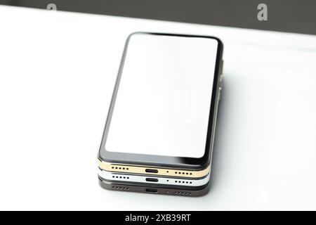 Stapel moderner Smartphones auf weißem Tisch Stockfoto