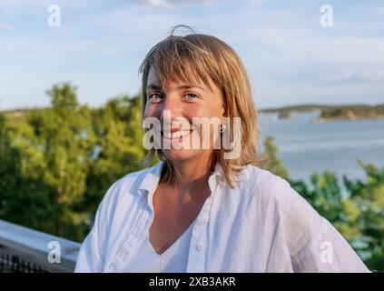 Porträt einer lächelnden jungen Frau mit blonden Pony Stockfoto