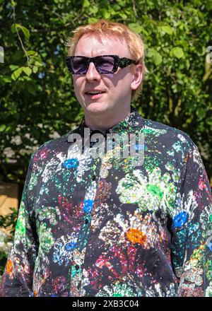 Joe Lycett, britischer Komiker, in farbenfroher Blumenmode auf der RHS Chelsea Flower Show in London Stockfoto