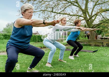 Ältere Frauen in Outdoor-Fitnesskursen, die aktiv in der Natur bleiben, andere dazu inspirieren, das Wohlbefinden zu priorisieren und Freunde in der freien Natur zu genießen Stockfoto