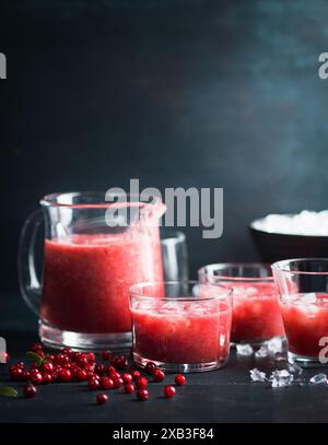 Kirschen in der Nähe von Saftkanne und Trinkgläsern auf dem Tisch Stockfoto