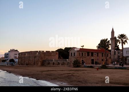 Larnaka, Zypern - 3. Februar 2024: Burg Larnaka und Minarett der Djami-Kebir-Moschee am mittelmeer bei Sonnenuntergang. Stockfoto